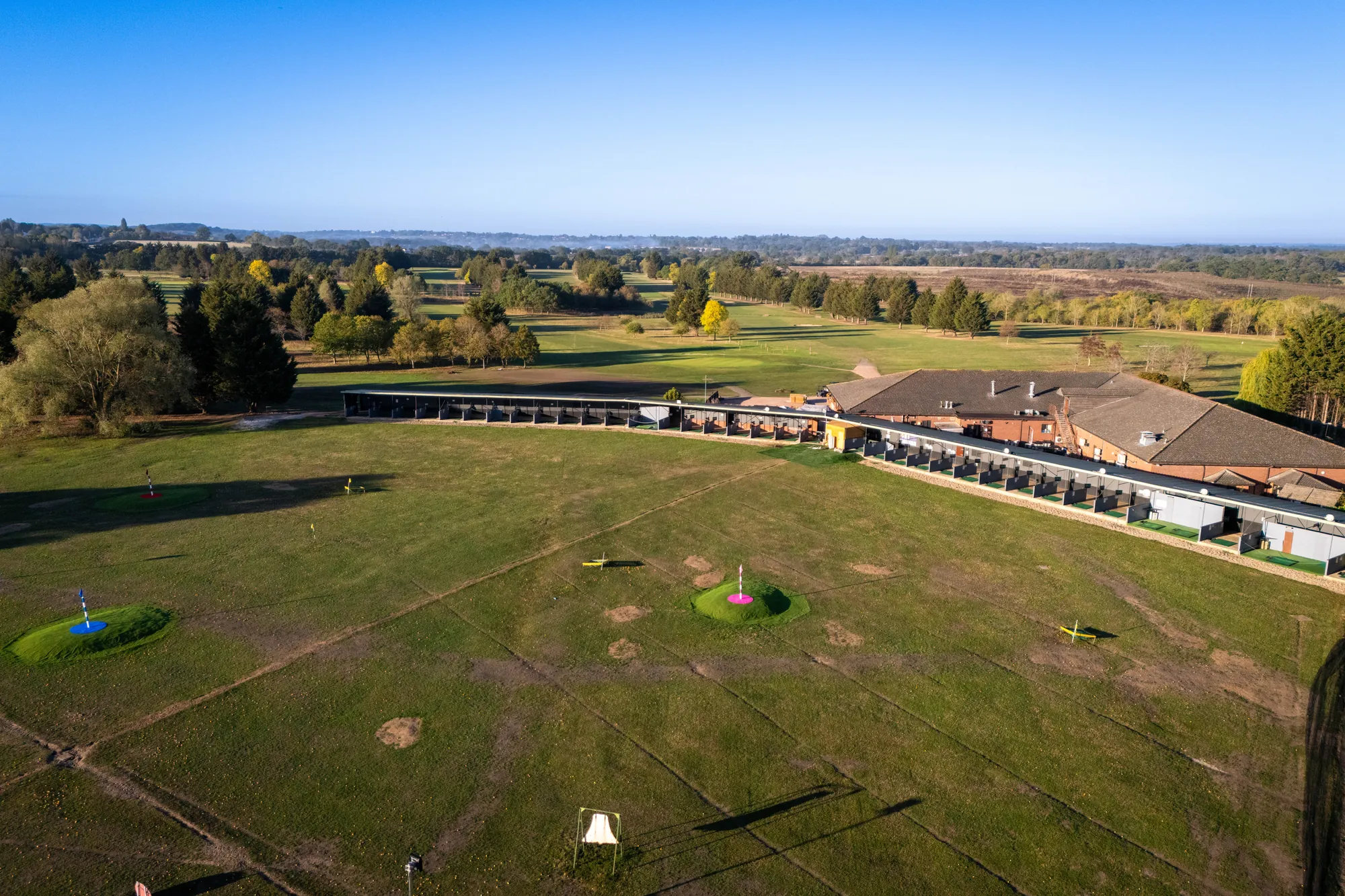 The driving range and clubhouse from the air, with target greens on the outfield