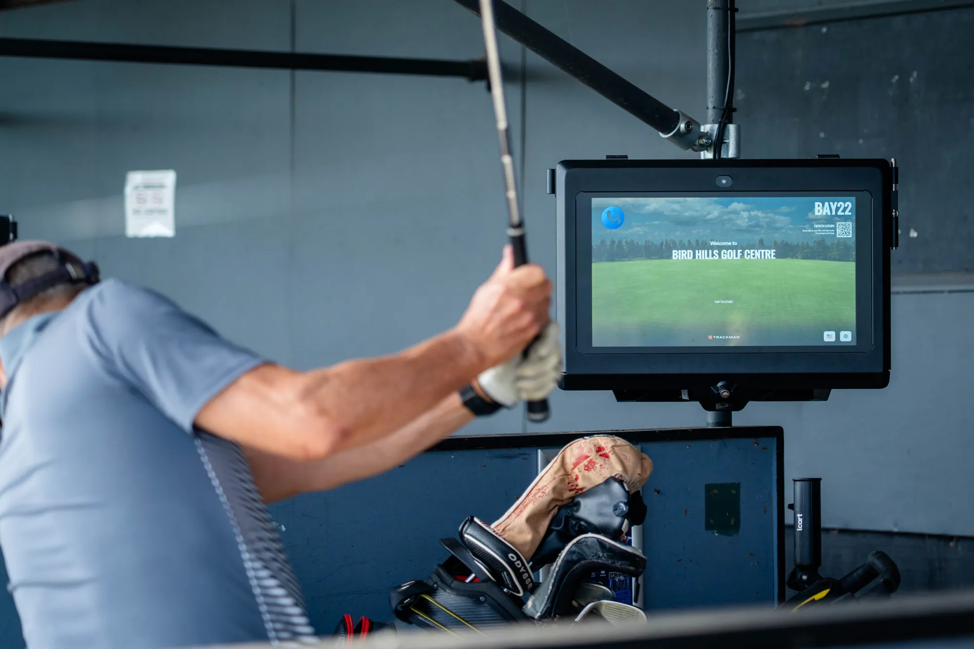 A TrackMan screen in a range bay as a golfer swings