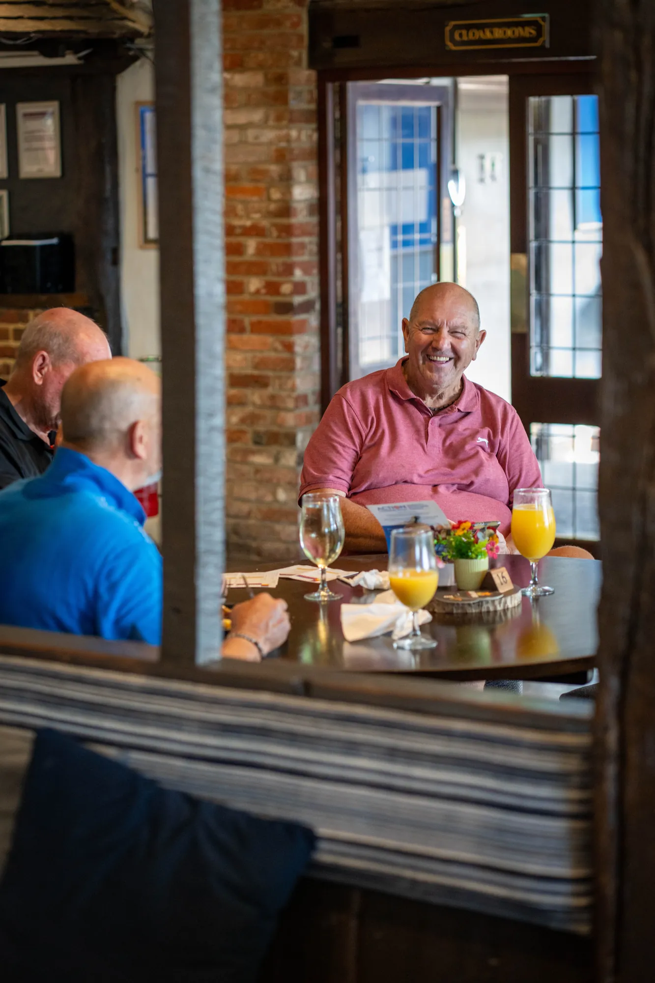 Golfers chatting over drinks at a table in the clubhouse