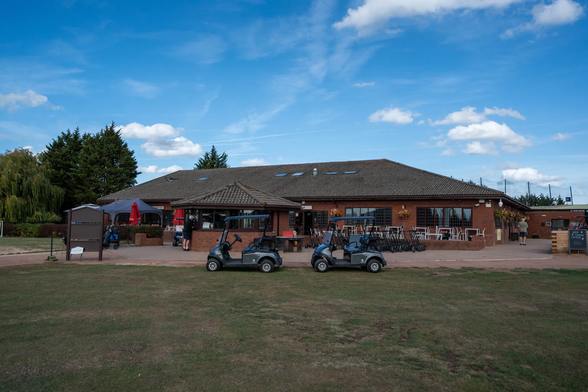 The clubhouse and terrace with buggies parked out front