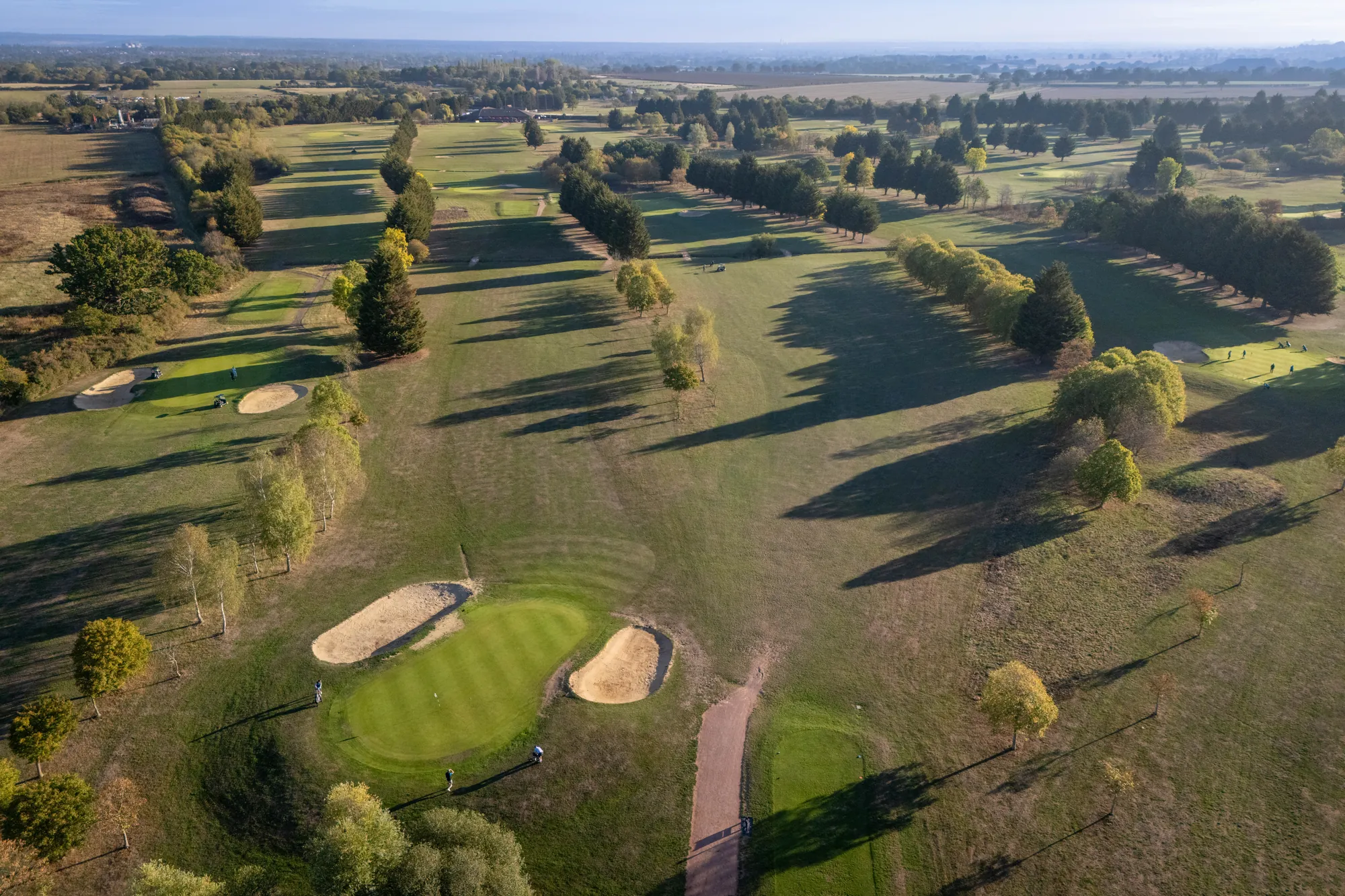 A green with two bunkers from the air, in early morning light